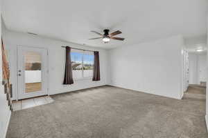 Unfurnished room with visible vents, baseboards, ceiling fan, light tile patterned floors, and light colored carpet