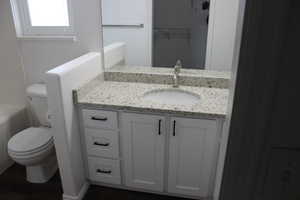 Full bath featuring wood finished floors, toilet, and vanity