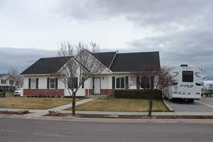 Ranch-style home featuring a front lawn and brick siding