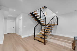 Stairway with baseboards, visible vents, wood finished floors, and recessed lighting