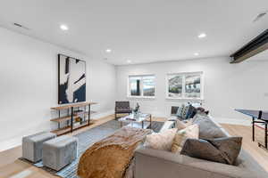 Living area featuring baseboards, recessed lighting, visible vents, and light wood-style floors