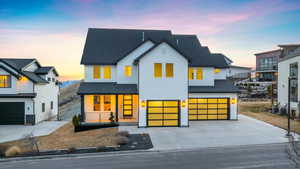 View of front facade with concrete driveway, central air condition unit, a porch, a garage, and a shingled roof