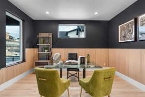 Office with a wealth of natural light, wood finished floors, recessed lighting, and wainscoting