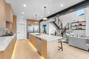 Kitchen featuring gas stovetop, a sink, light wood finished floors, modern cabinets, and light brown cabinets