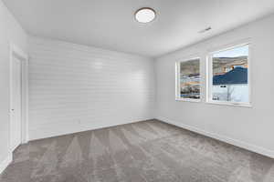 Carpeted spare room with baseboards and visible vents
