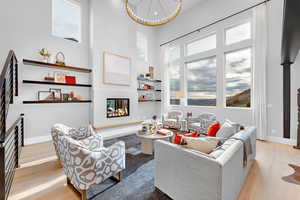 Living area featuring wood finished floors, a healthy amount of sunlight, and a glass covered fireplace