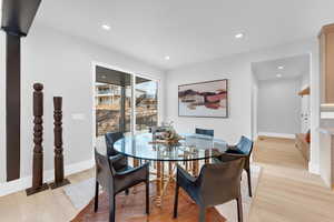 Dining area with baseboards, light wood-style floors, and recessed lighting