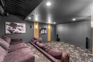 Carpeted cinema with baseboards, recessed lighting, and a textured ceiling