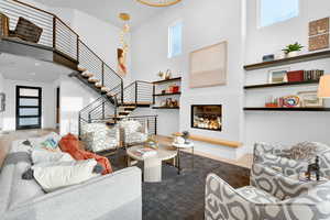 Living room featuring a high ceiling, plenty of natural light, and stairs