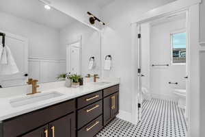 Bathroom featuring toilet, a sink, double vanity, and walk in shower