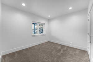 Empty room with baseboards, recessed lighting, and carpet
