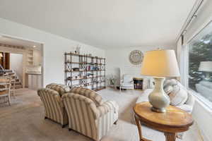 Living room featuring light colored carpet, stairs, and a glass covered fireplace