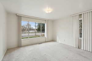 Empty room with visible vents and carpet flooring