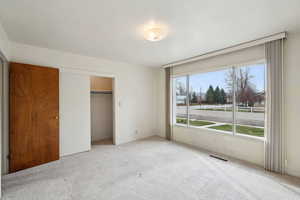 Unfurnished bedroom with a closet, visible vents, and carpet
