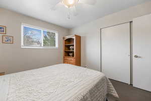 Carpeted bedroom with a closet and ceiling fan