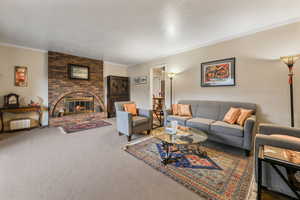 Carpeted living room with baseboards, a fireplace, ornamental molding, and a textured ceiling