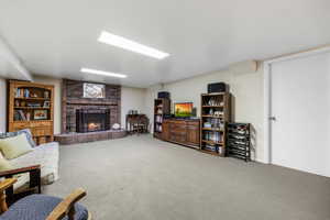 Carpeted living room with a brick fireplace