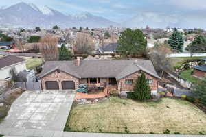 Ranch-style home featuring fence, a garage, a front yard, roof with shingles, and driveway