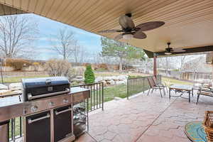 View of patio with ceiling fan, fence, and grilling area