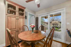 Dining area with a ceiling fan, baseboards, and light wood-style flooring