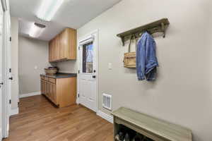 Kitchen featuring a textured ceiling, visible vents, dark countertops, open shelves, and light wood-style floors