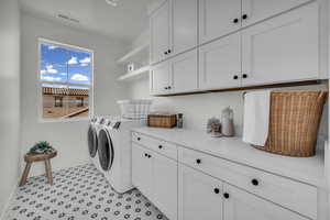 Laundry room featuring baseboards, cabinet space, visible vents, and independent washer and dryer