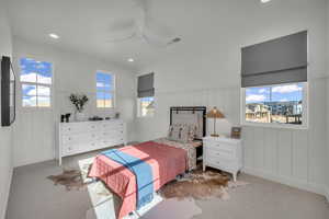 Carpeted bedroom with a wainscoted wall, recessed lighting, a ceiling fan, and a decorative wall
