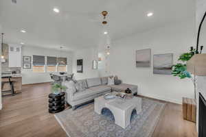 Living area with baseboards, light wood-style flooring, visible vents, and recessed lighting