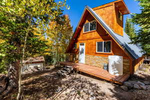 Back of house featuring stone siding and metal roof