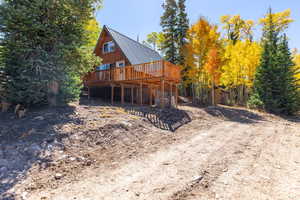 Rear view of property featuring metal roof, a standing seam roof, and a deck
