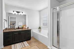 Full bathroom with a shower stall, stone tile floors, and a garden tub