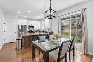 Dining area featuring an inviting chandelier, a wealth of natural light, recessed lighting, and wood finished floors
