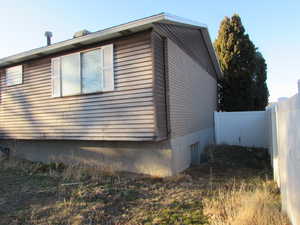 View of back and side of property featuring fence.