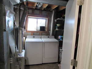 Laundry area with laundry area and washing machine and clothes dryer. This room also has large storage area with shelving.