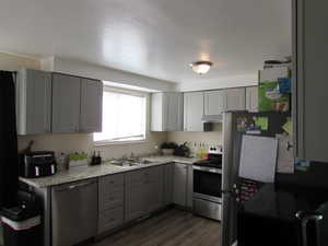 Kitchen with a sink, cabinets, under cabinet range hood, and stainless steel appliances