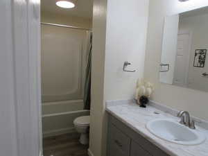 Full bathroom with vanity, toilet, and shower / tub combination.