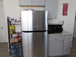 Kitchen featuring counters, laminate floors, freestanding refrigerator.