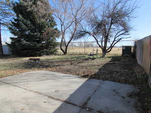 View of back yard with a patio and fence.