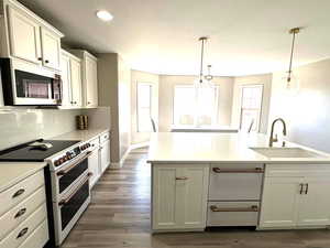 Kitchen with light quartz countertops, white appliances, tasteful backsplash, a sink, and dark wood-style floors