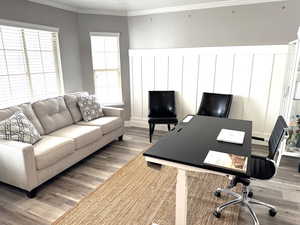 Home office featuring crown molding, bay window and wood finished floors