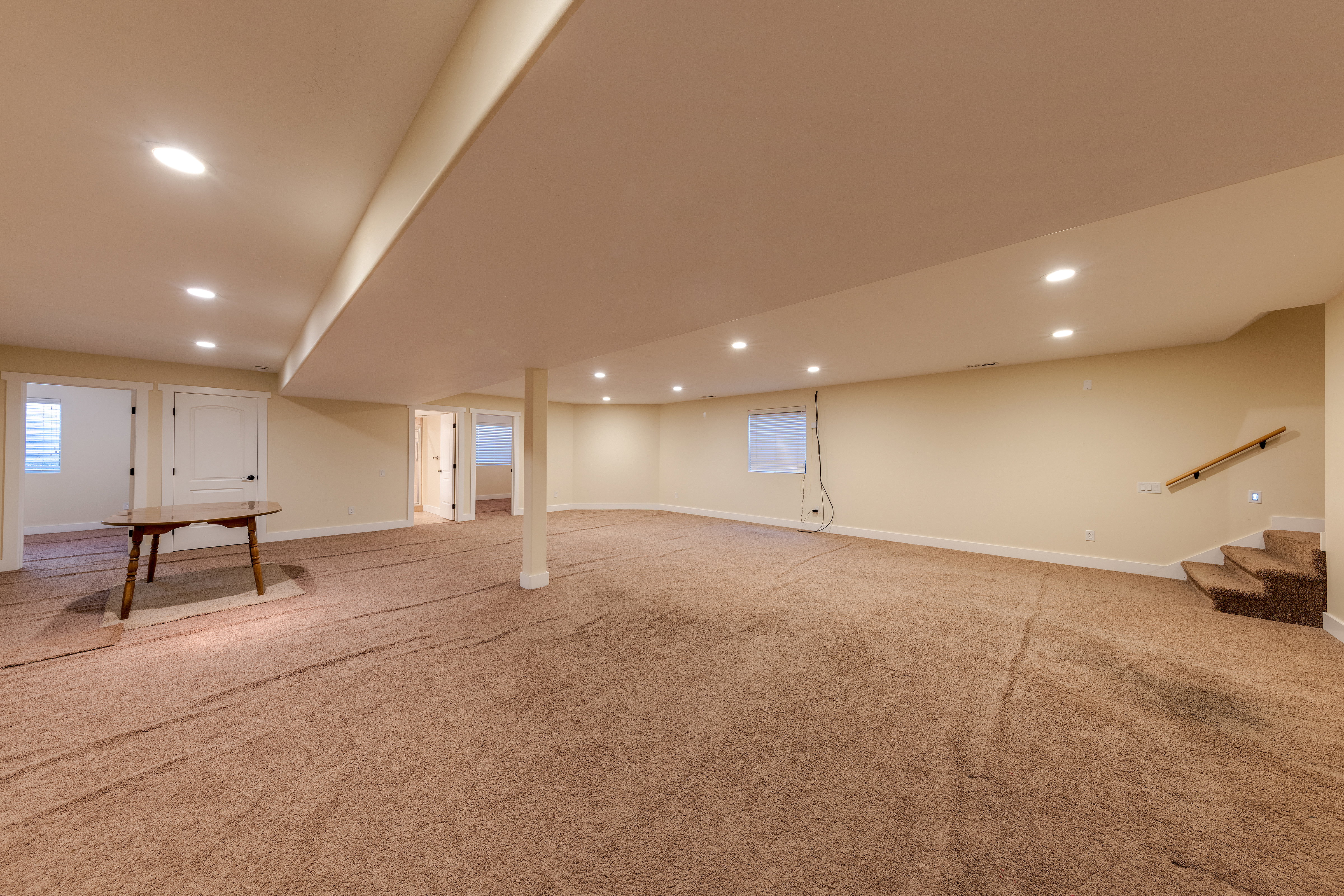 Below grade area featuring baseboards, stairway, light colored carpet, and recessed lighting
