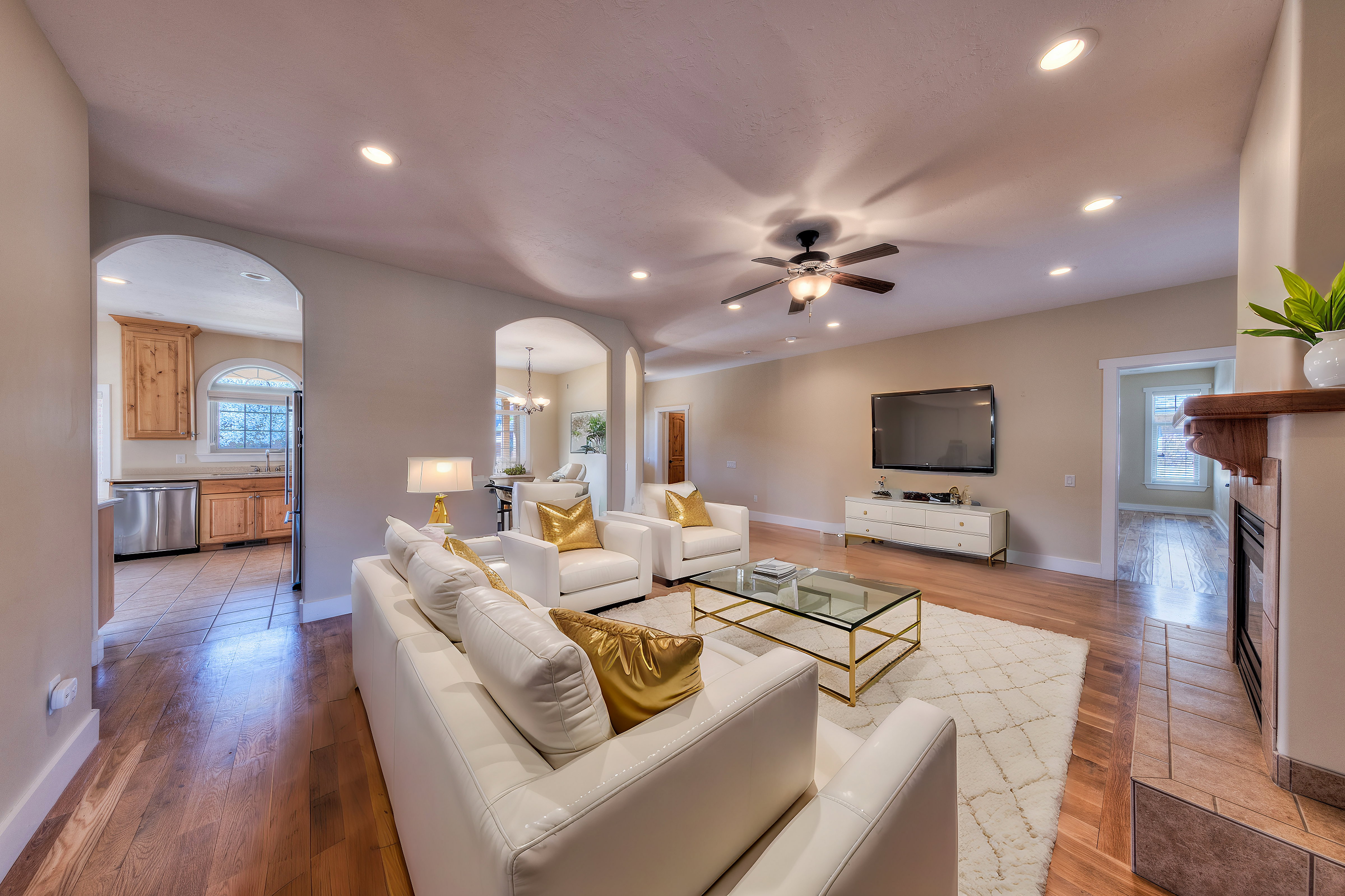 Living room with light wood-style flooring, arched walkways, and recessed lighting