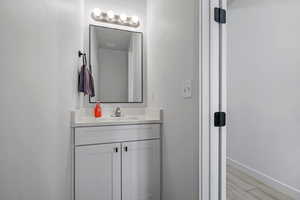 Bathroom with vanity, baseboards, and wood finished floors