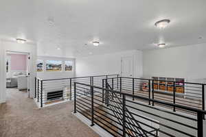 Corridor featuring an upstairs landing, carpet floors, and recessed lighting