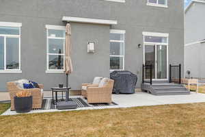Rear view of property with stucco siding, a yard, and a patio