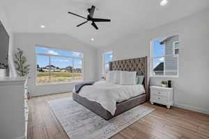 Bedroom with lofted ceiling, light wood-style flooring, baseboards, ceiling fan, and recessed lighting