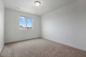 Carpeted spare room with baseboards and visible vents