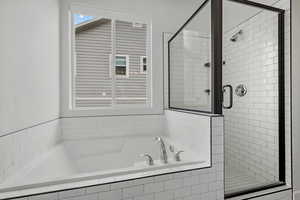 Full bath with a stall shower and a bath