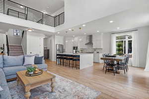 Living area with light wood finished floors, a wealth of natural light, recessed lighting, and stairway
