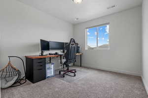 Office space with baseboards, carpet flooring, and visible vents